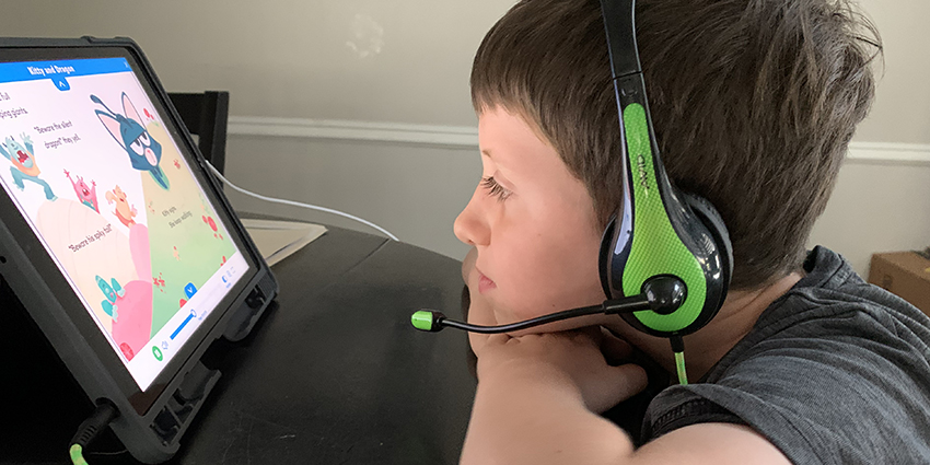 Young boy with headphones watching computer tablet
