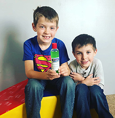 Photo of two boys at child care center with donated hand sanitizer