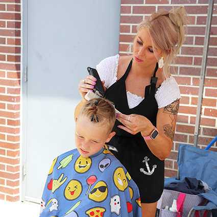 Woman giving boy a haircut