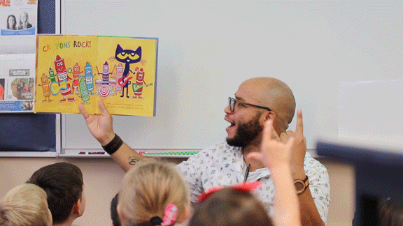 Raydell Cordell Showing A Book To Children