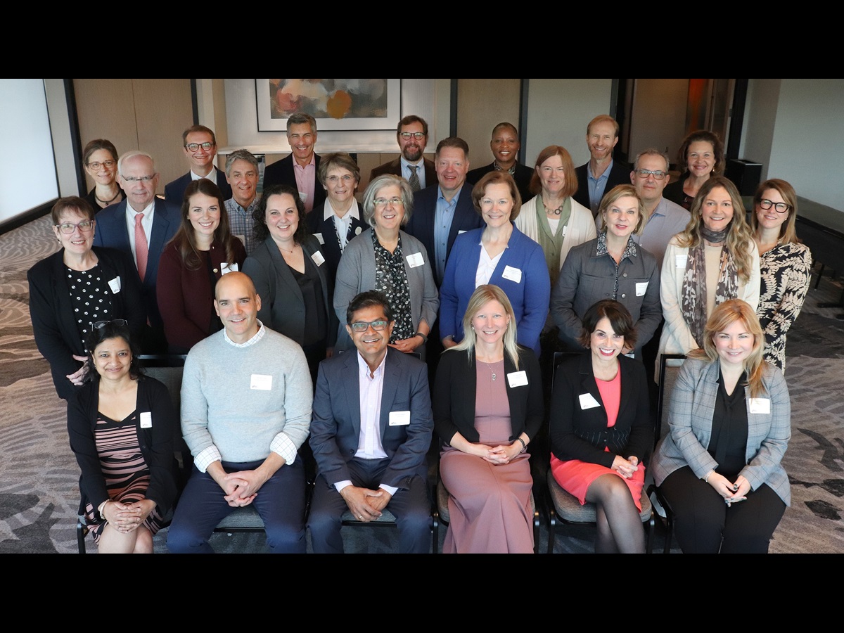 A posed group shot of economists and child care experts gathered in Omaha in October 2024