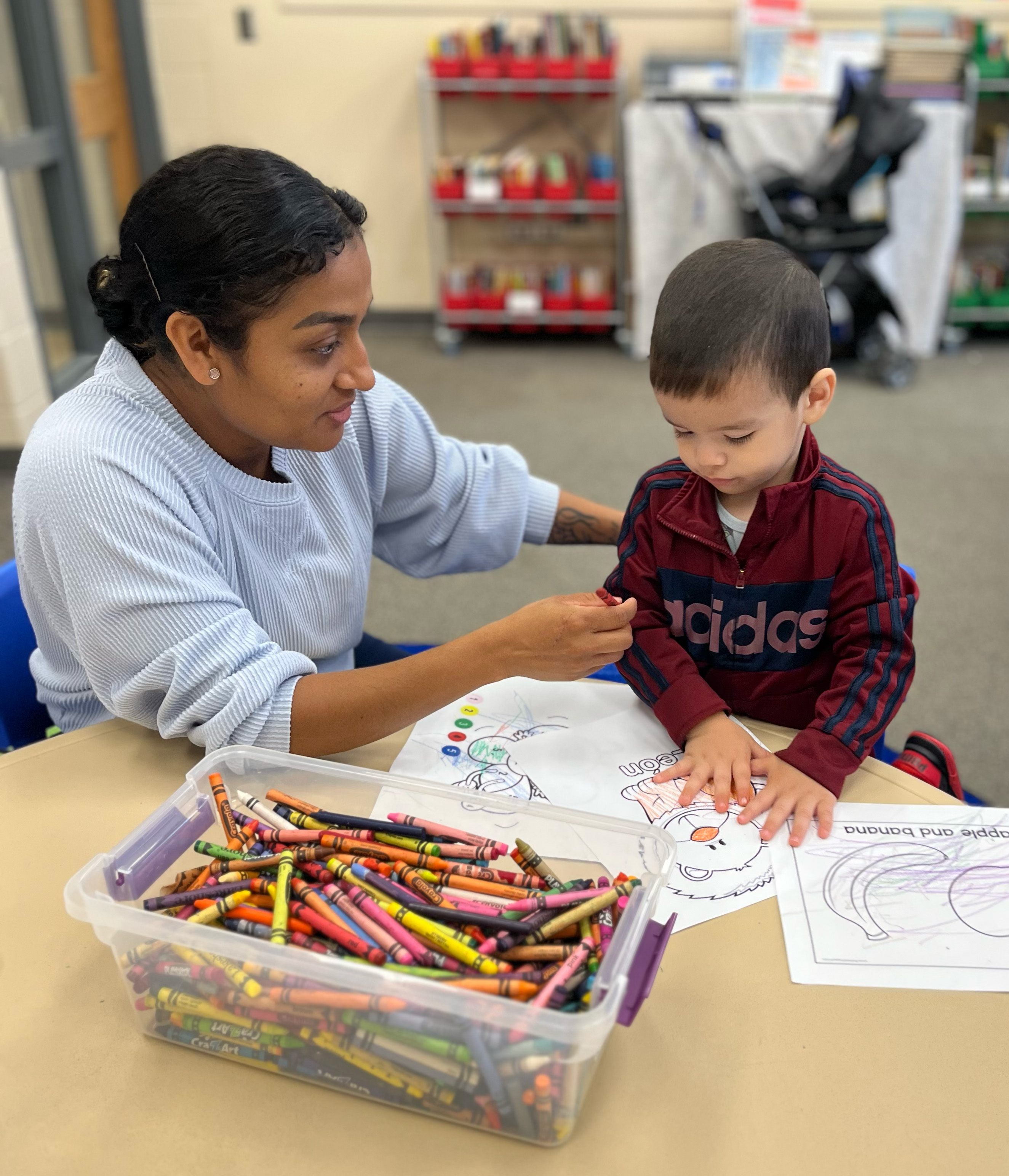A little boy sits at a table coloring