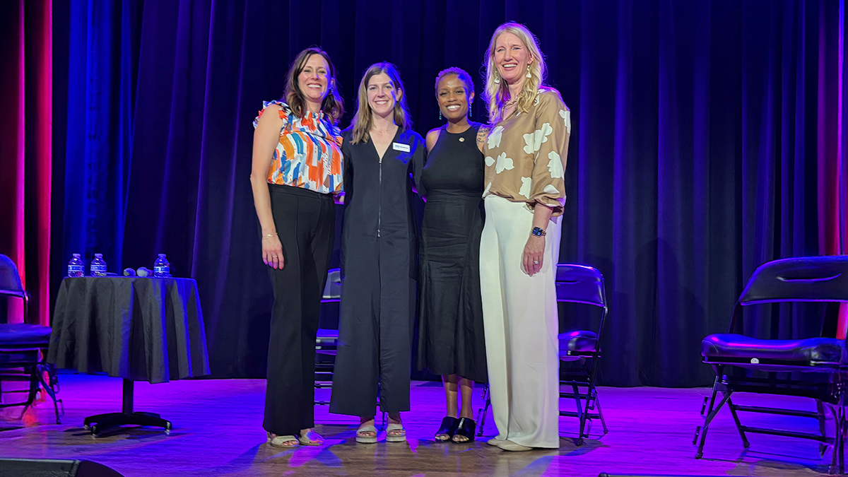 Four women standing together on a stage 