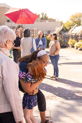 A girl hugs a former teacher