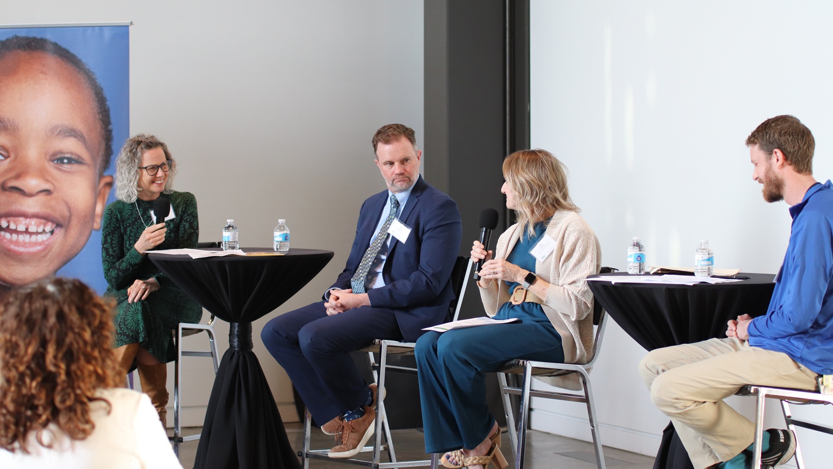 Two women and two men participate in a panel discussion at an event
