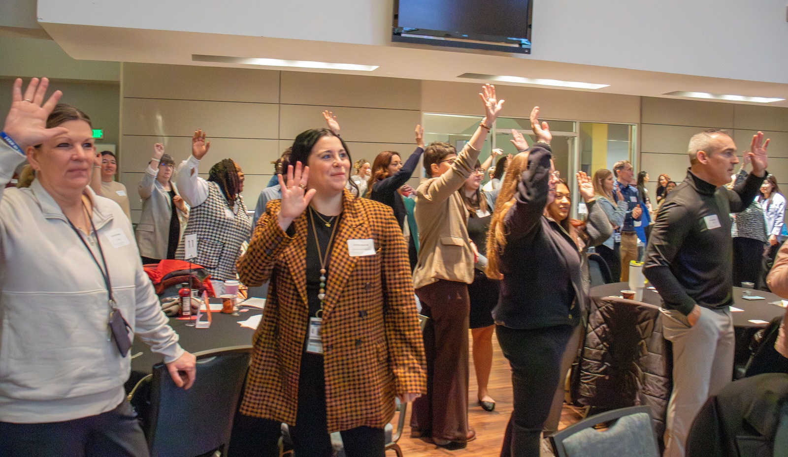Attendees at the 2026 Superintendents' Early Childhood Plan convening stand and raise their hands