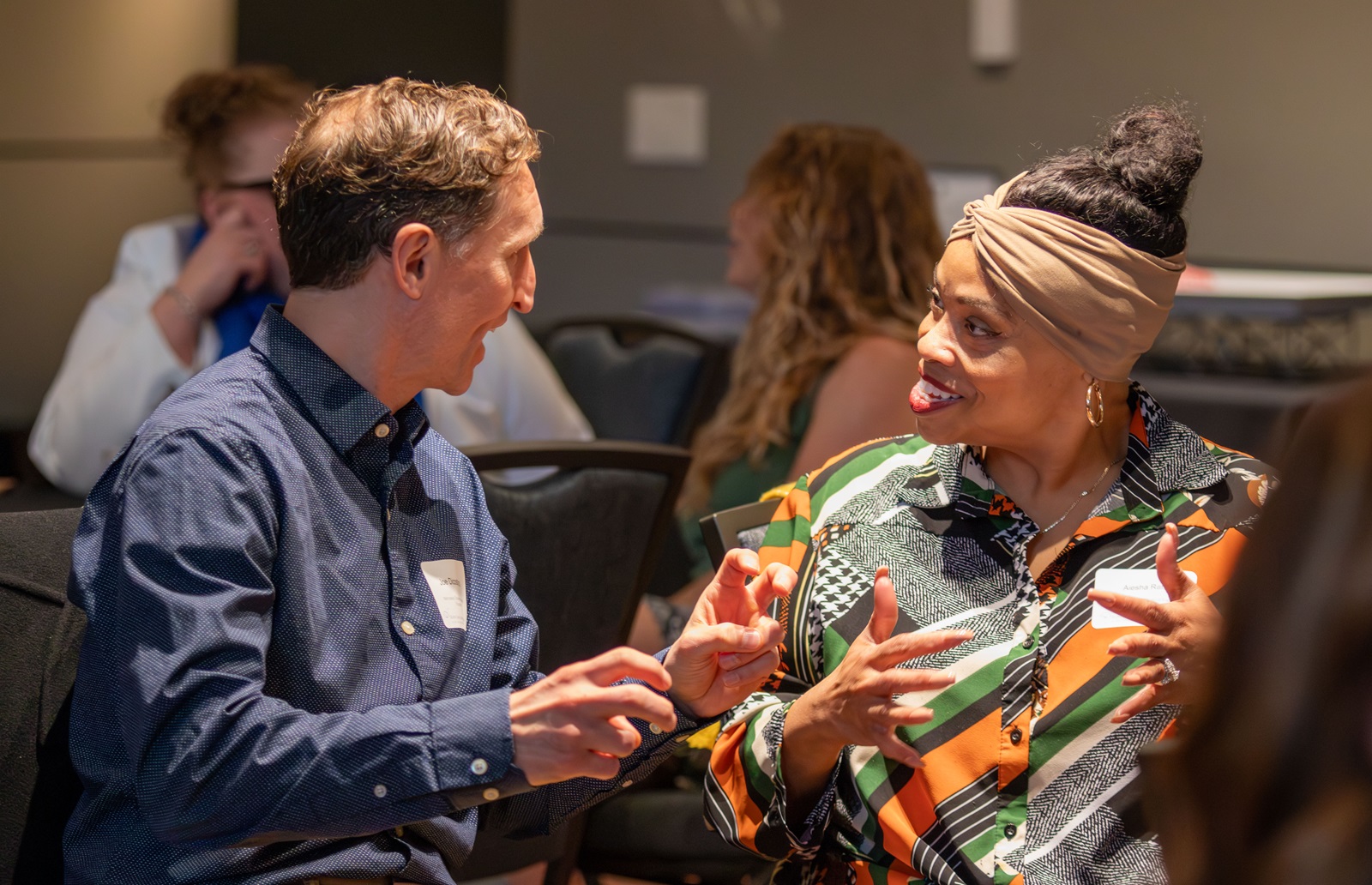 Two attendees at the 2026 Superintendents' Early Childhood Plan convening speak to each other