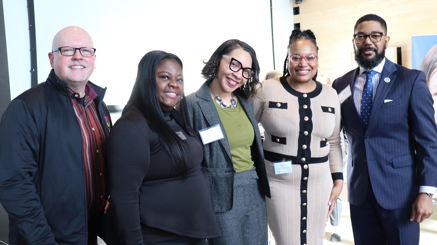 Five men and women standing together at an event