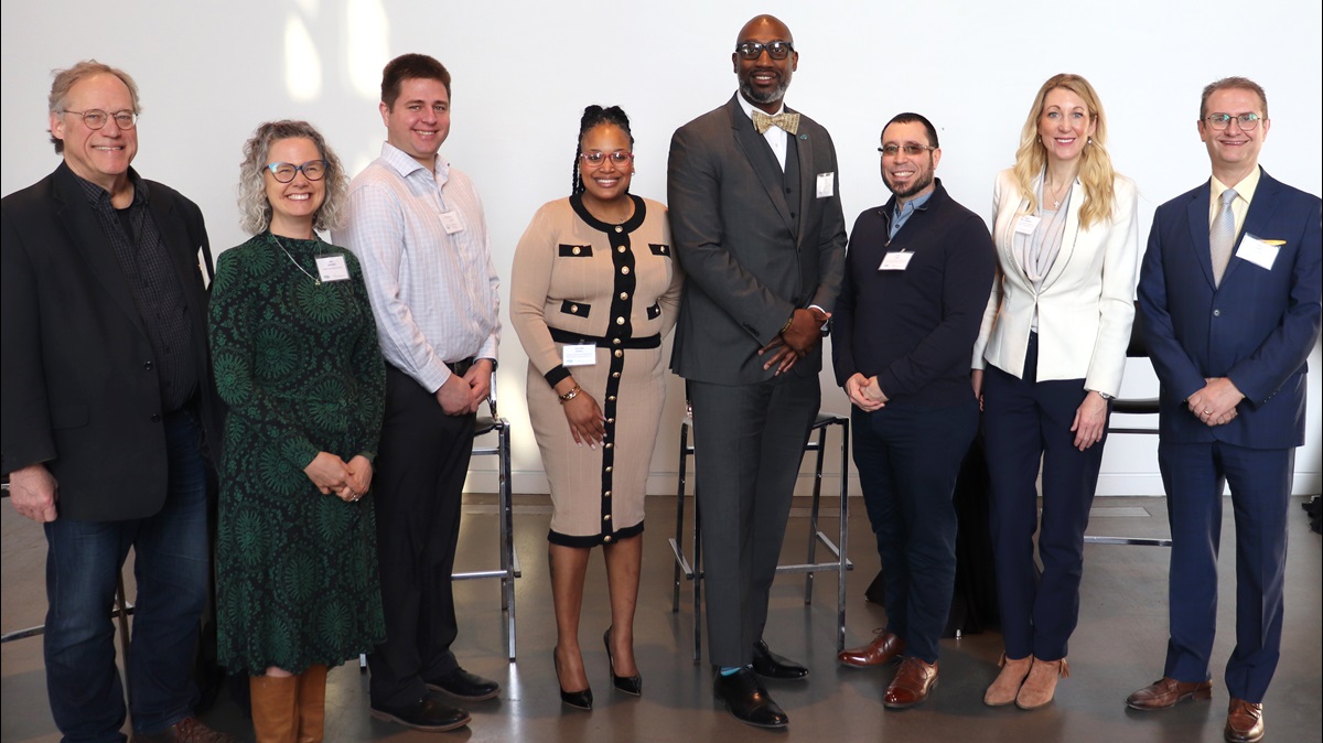 Eight people standing together at an event