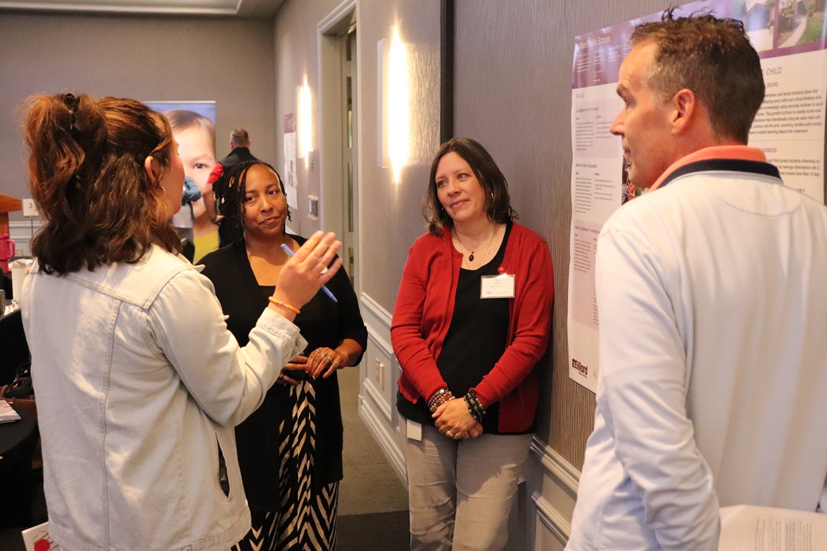 A small group of people standing around a data poster