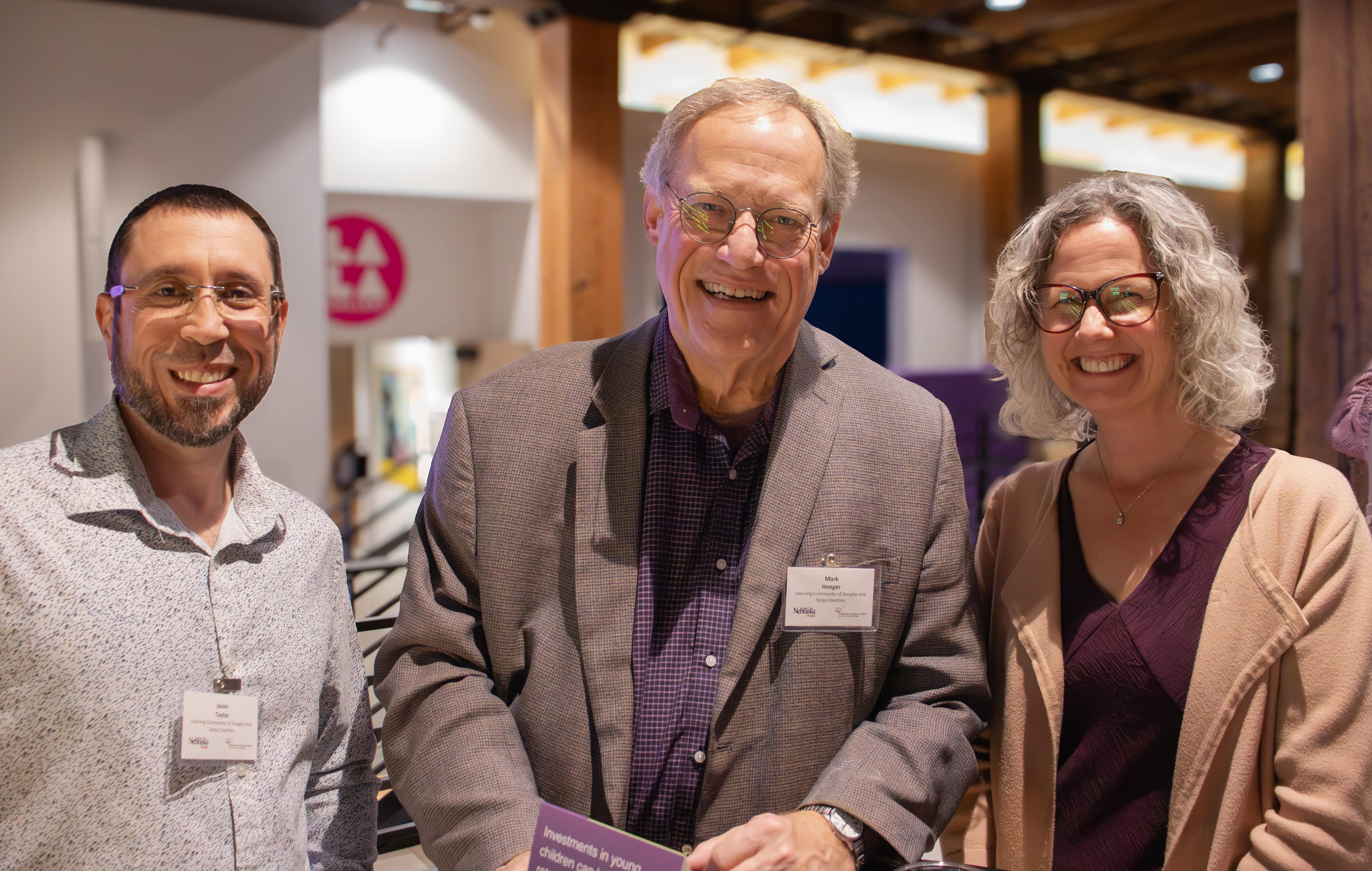 Two men and a woman pose together at the UNO community chair event on Oct. 22, 2025