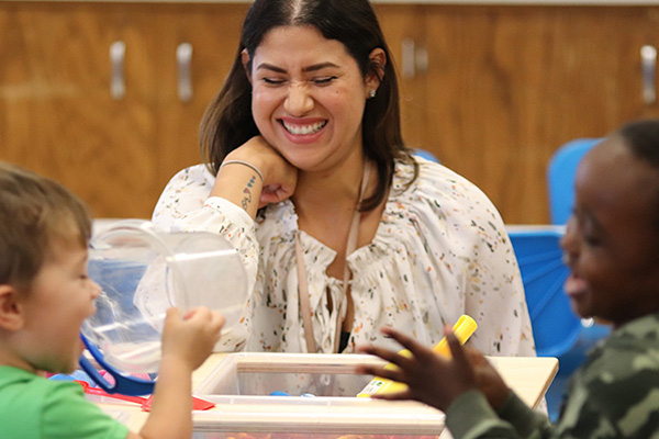 Teacher laughing with two little kids at Mockingbird Elementary School