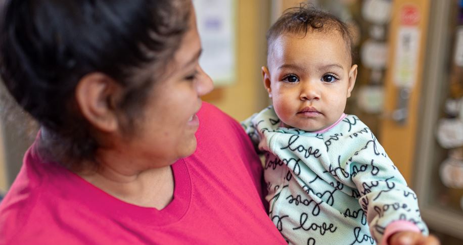 Front cover of a policy brief report with a woman holding a baby