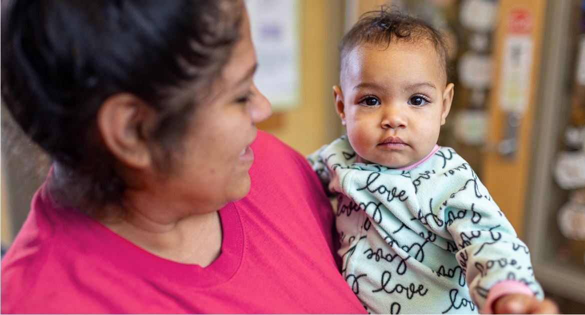 A child care provider holding a baby