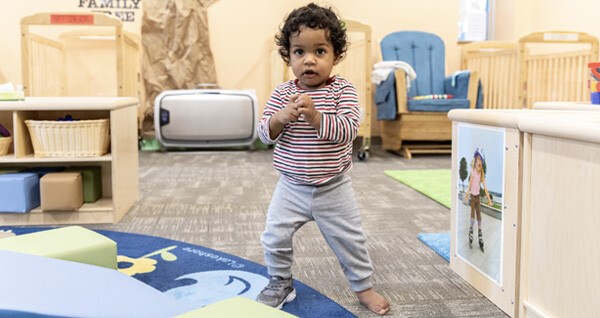 A toddler standing inside a classroom
