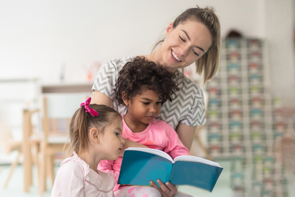 A teacher reading to two young children