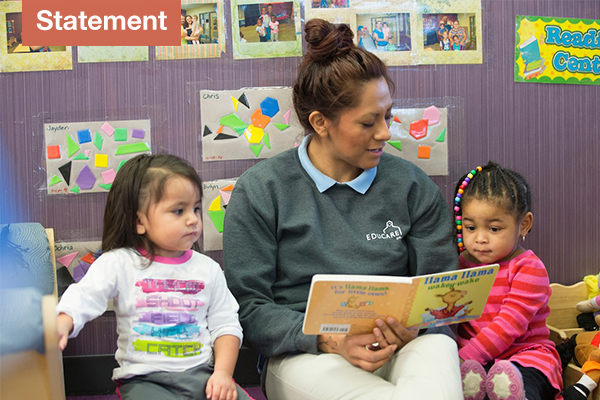 An indoor classroom photo featuring an educator reading a book titled "Llama Llama Wakey-Wake" to two young children, with a "Statement" graphic overlay in the top-left corner.