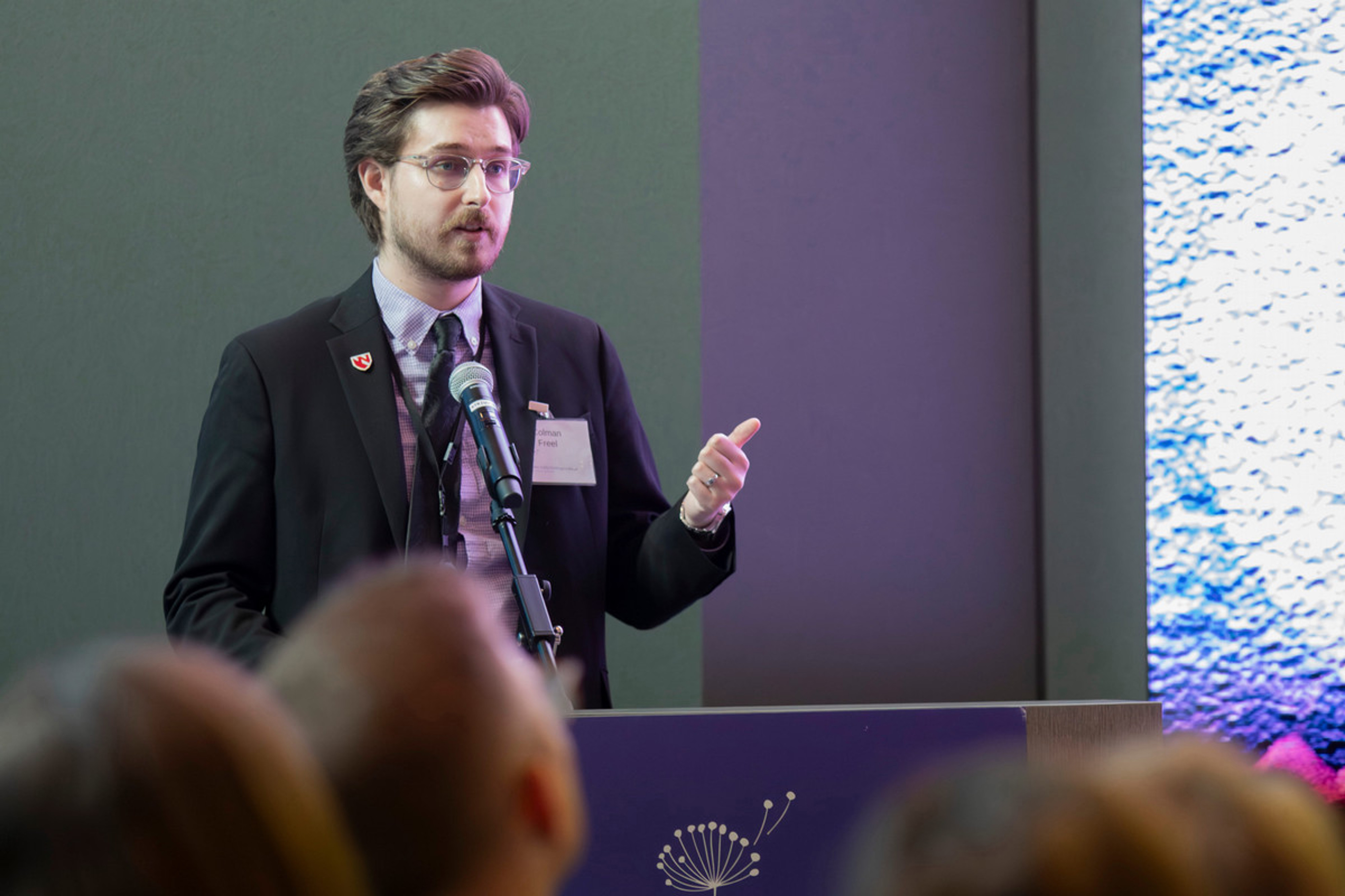 University of Nebraska Medical Center Ph.D. student Colman Freel presents his research while standing at a podium