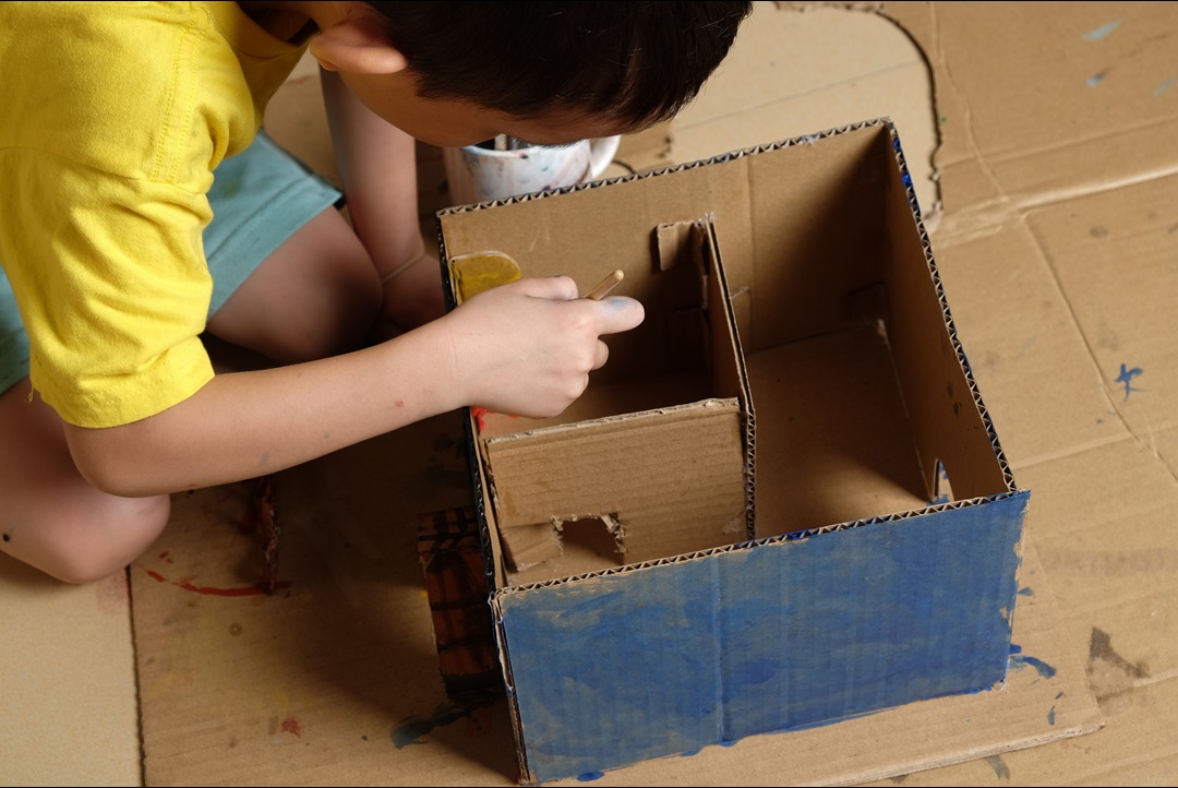 Child playing with a cardboard box 