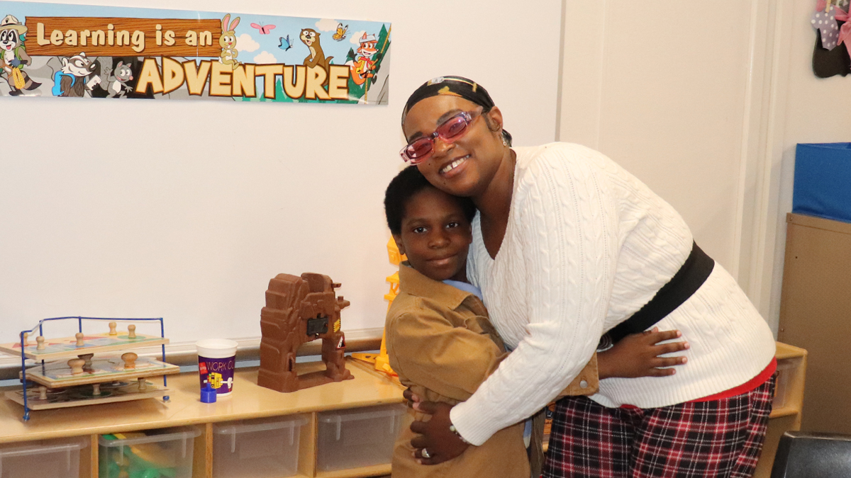 A fourth-grade boy and his mother hug inside a school