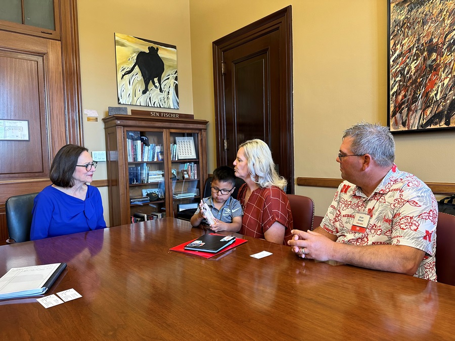 The Gibson family meets U.S. Sen. Deb Fischer in a conference room. 