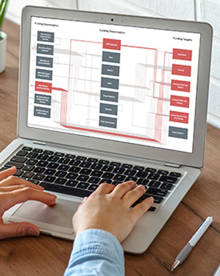 A man in a blue suit holds a microphone and speaks onstage at the 2026 Superintendents' Early Childhood Plan annual convening